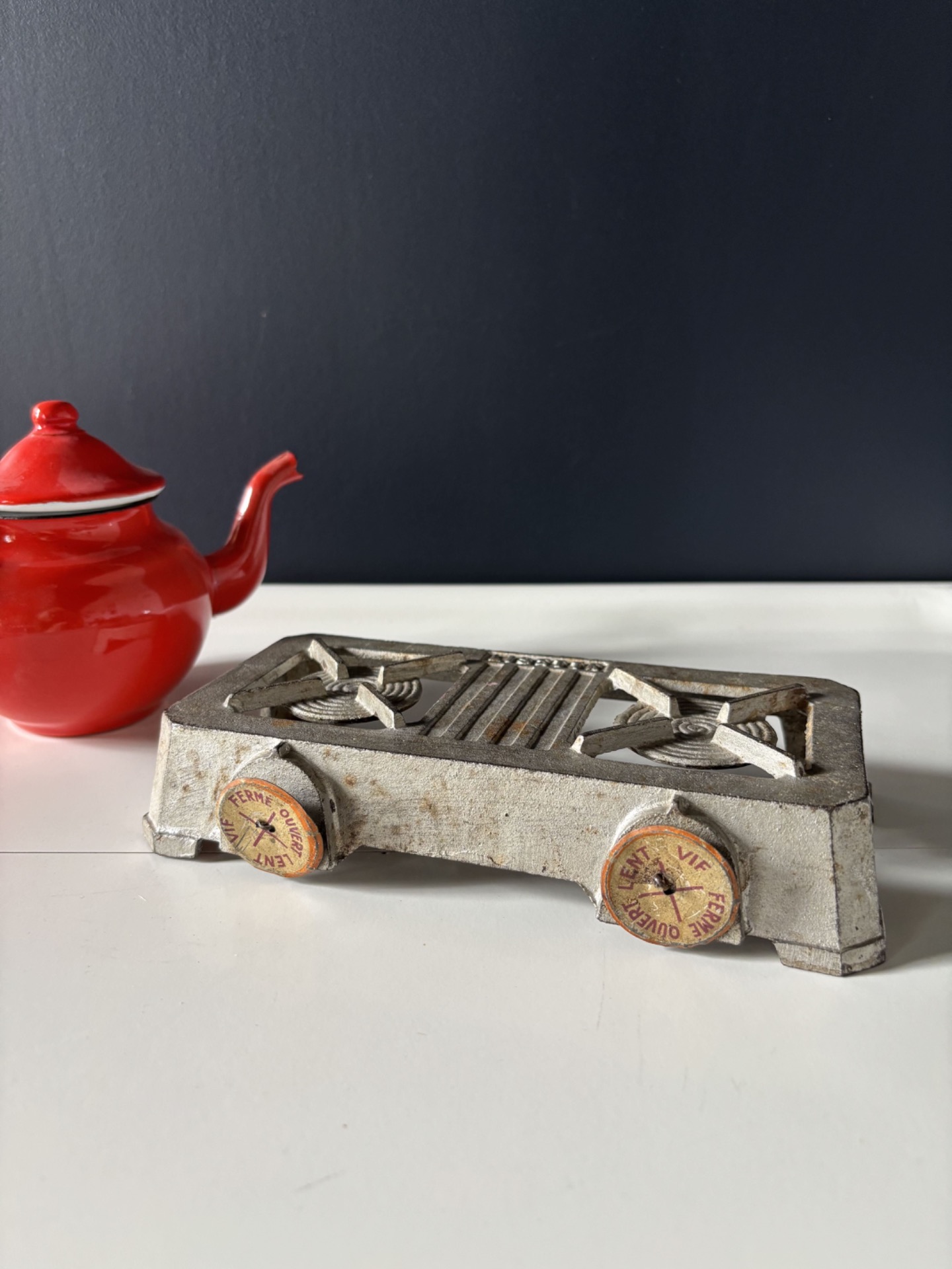 Jouet vintage cuisinière miniature en métal des années 1950, objet de collection rétro avec boutons d’origine.
