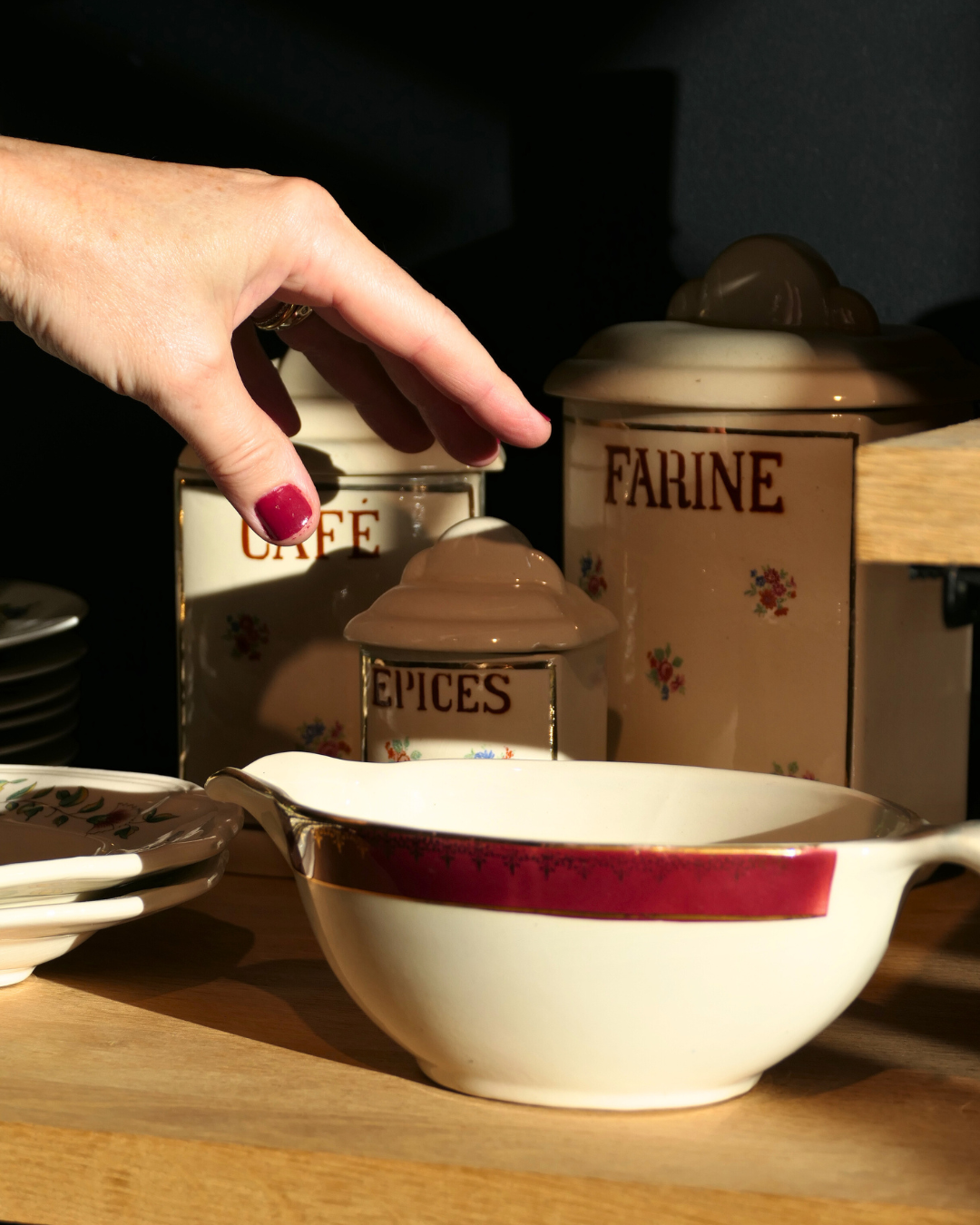 Main chinant des pots en faïence vintage Café Farine Épices — La Cocotte en Papier Vannes